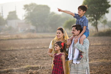 Happy rural Indian family on agricultural field