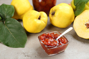 Delicious quince jam and fruits on light grey table
