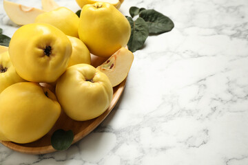 Fresh ripe organic quinces on white marble table. Space for text