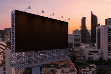 Blank black road billboard with Bangkok cityscape background at night time. Street advertising poster, mock up, 3D rendering. Side view. The concept of marketing communication to promote idea. © VideoFlow