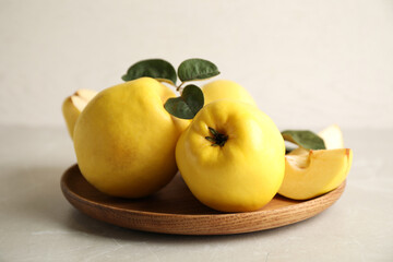 Fresh ripe organic quinces with leaves on light table