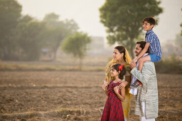 Happy rural Indian family on agricultural field
