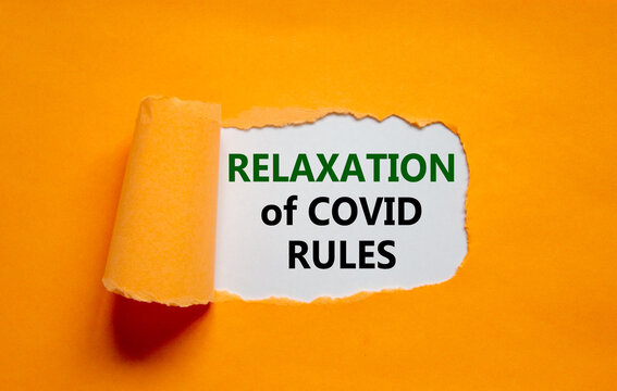 Relaxation of covid rules symbol. Words 'Relaxation of covid rules' appearing behind torn orange paper. Business, medical and relaxation of covid rules concept. Copy space.