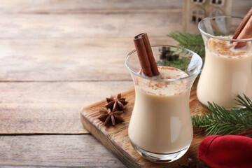 Delicious Christmas liqueur on wooden table, closeup. Space for text