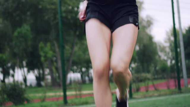 Young sportive woman trains with ladder drills . Close-up of the legs. Live camera. Front view.