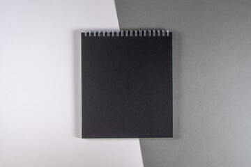 centered black notebook on white gray background