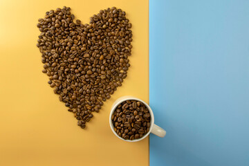 Stylish set: a cup of roasted coffee beans on a pastel background. Flat lay. View from above.
