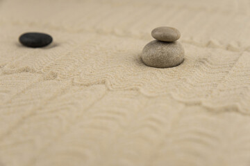 Fototapeta premium Zen sand garden meditation stone background with copy space. Stones and lines drawing in sand for relaxation. Concept of harmony, balance and meditation, spa, massage, relax. Set Sail Champagne color