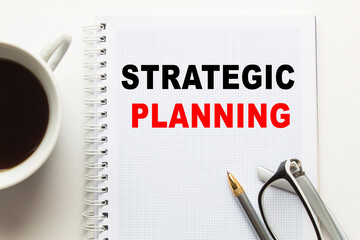 Notepad with inscriptions STRATEGIC PLANNING on a white background. business concept.