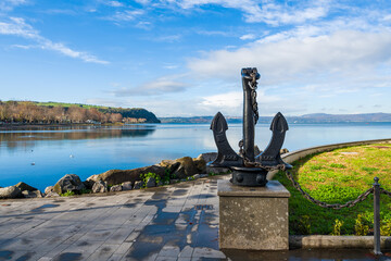 Monument of a metal anchor in the bay of the italian city called Anguillara