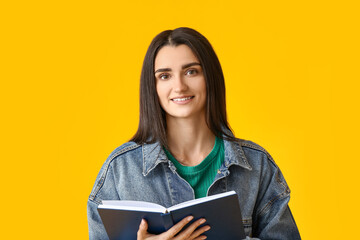 Fototapeta premium Young woman with book on color background