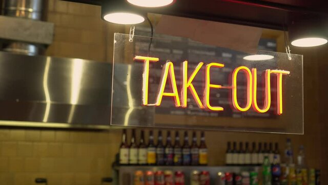A cafe owner puts a TAKE OUT ONLY sign . Take out or carry away quickly became the only option for restaurants and bars during the coronavirus COVID-19 pandemic of 2020.