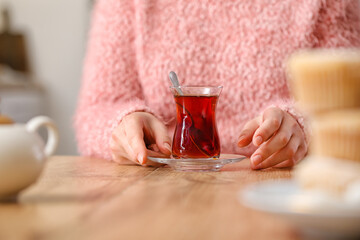 Woman drinking Turkish tea at table