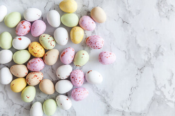 Naklejka na ściany i meble Happy Easter concept. Preparation for holiday. Easter pastel candy chocolate eggs sweets on trendy gray marble background. Simple minimalism flat lay top view copy space.