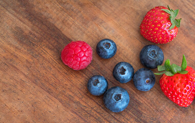 Fresh mix berries on wooden rustic   background. Strawberry, Raspberry and Blueberry, Top view.
