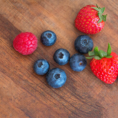 Fresh mix berries on wooden  background. Strawberry, Raspberry and Blueberry, Top view.  Copy space