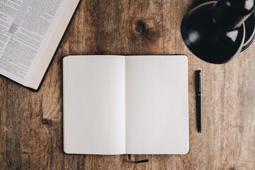 Blank notebook for bible study on a wooden desk. Top view flat lay.