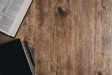 An open bible and notebook for bible study on a wooden desk.Top view flat lay.