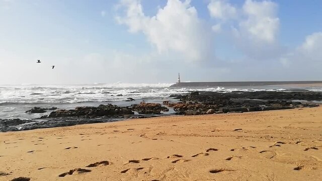 Beach waves with a beacon in the background