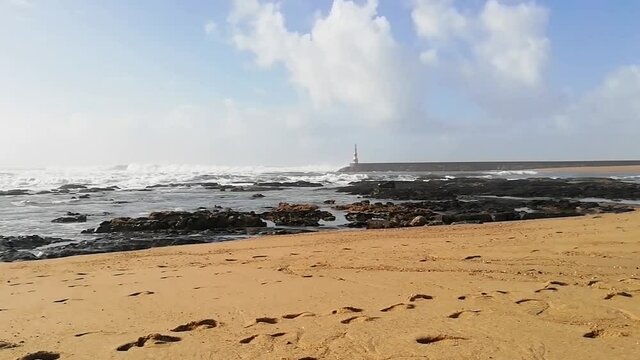 Timelapse of Beach waves with a beacon in the background