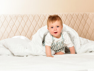 Fototapeta premium Happy cheerful baby in the interior of the bedroom. Laughter.