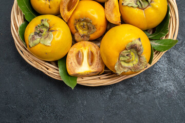top view fresh sweet persimmons inside basket on the dark background fruit ripe tree taste