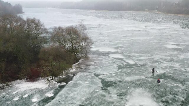 top view of an island in the middle of a frozen lake and fishermen catching fish