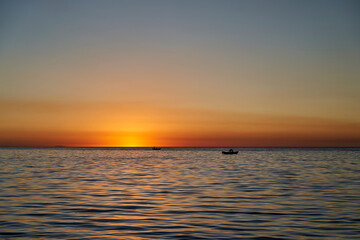 Beautiful golden sunset over lake titicaca with the silhouette of a fisherman in his boat, close to copa cabana in Bolivia, South America