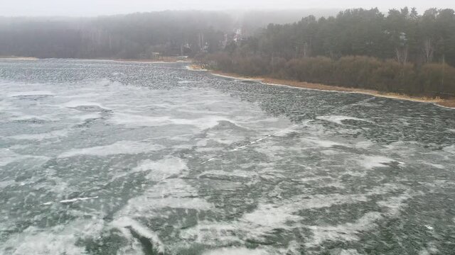 top view of an island in the middle of a frozen lake and fishermen catching fish