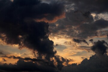 great clouds in the sky, the light of the setting sun between rolling puffed clouds