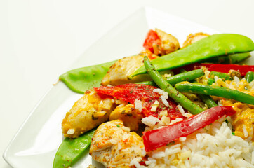 Chicken breast pieces in a Thai red curry sauce made with coconut cream, red chillies, lemongrass, lime leaf, with fragrant rice, red peppers, mange tout, and green beans