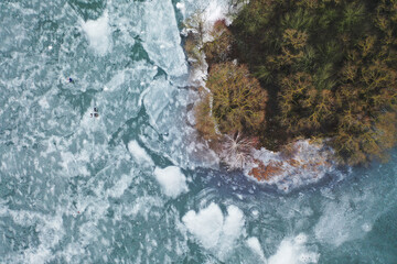 top view of an island in the middle of a frozen lake and fishermen catching fish