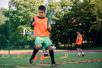 Children's football players during team training before an important match. Exercises for the youth football team.