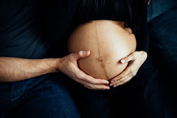 Close up photo shoot of pregnant bump with hands on it.