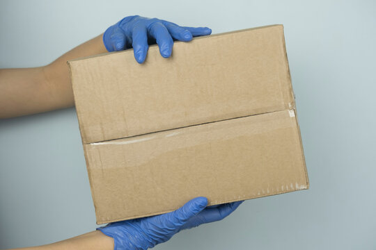 Delivery woman holding cardboard boxes in medical rubber gloves and mask. copy space. Fast and free Delivery transport . Online shopping and Express delivery . Quarantine. the girl is a volunteer.