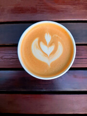 top view fresh coffee with milk foam and art on a wooden background