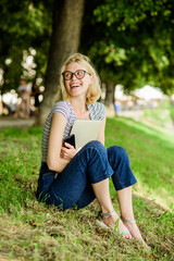 Obraz premium Closer to nature. Nature inspiring environment. Girl carefree student worker laptop relaxing outdoors sit green grass. United with nature. Summertime concept. Take break and relax. Simple happiness