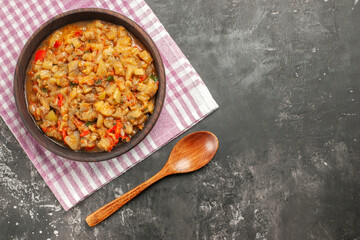 top view roasted eggplant salad in bowl on pink white checkered tablecloth wooden spoon on dark background copy space