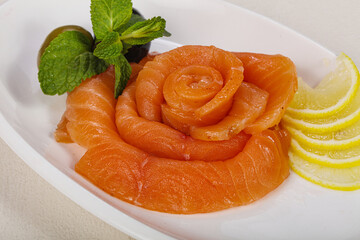 Sliced salmon snack with lemon