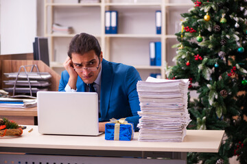 Young male employee working in the office at Chrismas