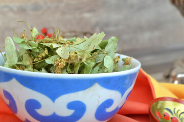 Plate with linden flowers or dry linden tea close up