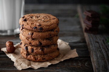 Chocolate cookies with glass of milk on wooden table.