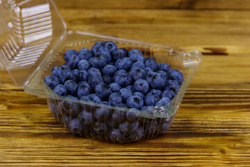 Fresh blueberry in plastic box on a wooden table