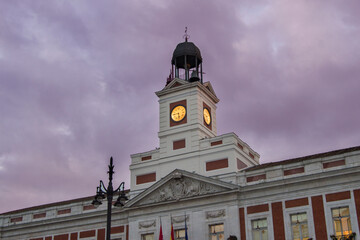 Fototapeta na wymiar building of the Community of Madrid with the illuminated clock at dusk, in Madrid. Spain