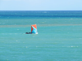 Martinican traditional sailboat sailing in the caribbean sea. Gommiers and yoles. Yole boat in...
