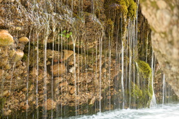 Water flowing from the rock to Alpine stream
