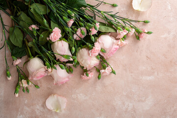 Overhead view of pink flowers on light surface, roses flat lay