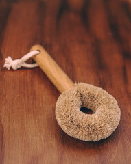Fototapeta na wymiar Eco wooden dish washing brush with coconut bristle at wooden background. Zero waste concept.