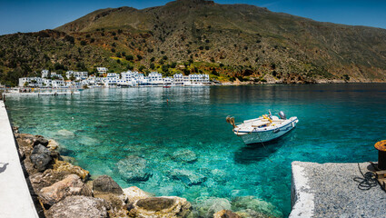View over motor boat moored on Greek harbor coastline