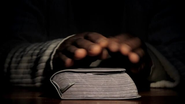 man praying to god with hands on bible praying with black background stock video